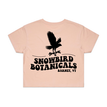 Load image into Gallery viewer, Pink Crop Top with a big design on the back of a snowbird and the text &quot;Snowbird Botanicals Barnet, VT&quot; underneath.
